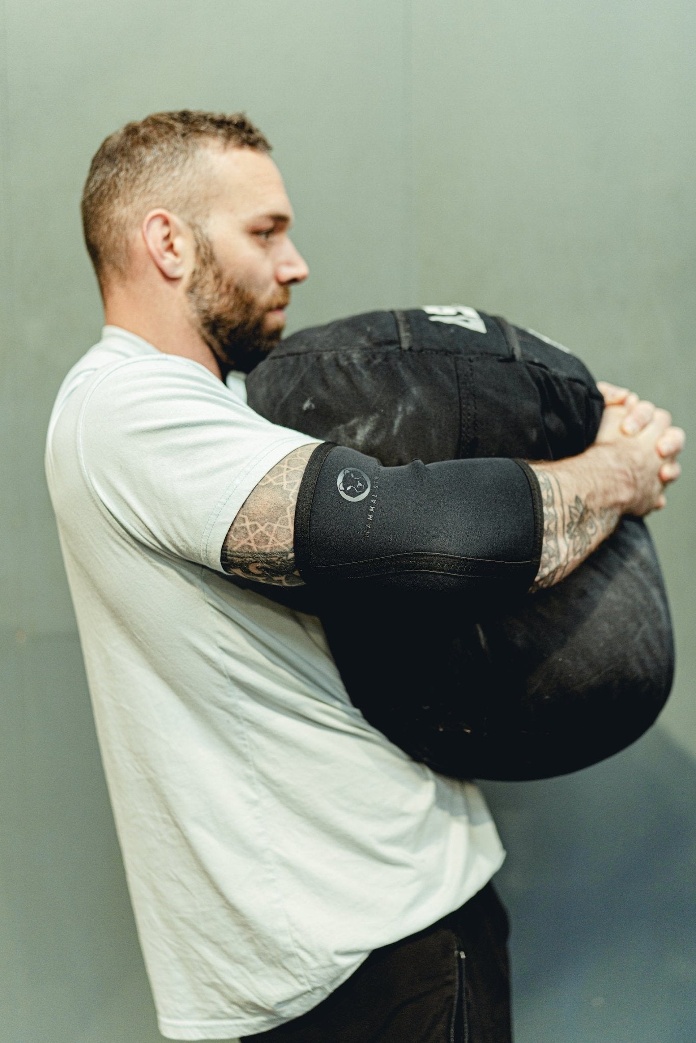 Pair of Mammal Strength 5mm black neoprene elbow sleeves designed for compression, joint support, and durability during strength training