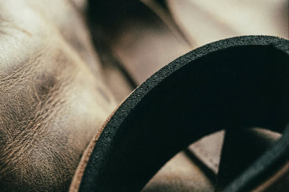 Close-up detail of brown leather Olympic weightlifting strap material with black elastic band